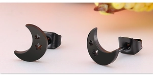 Détail macro de boucles d'oreilles lune noires avec découpes d'étoiles et fini métal