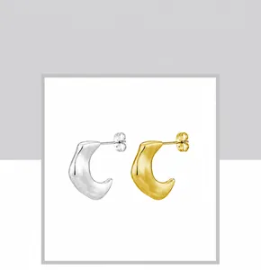 Macro view of gold and silver crescent moon bamboo earrings with butterfly backings