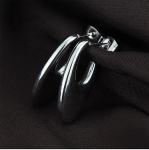 Macro view of teardrop hollow titanium steel stud earrings with mirror polished finish