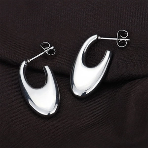 Detailed close-up of C-shaped crescent moon stud earrings with silver high-polish finish