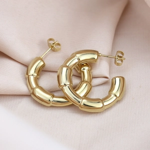 Elegant gold bamboo crescent C-shaped titanium steel stud earrings on pink silk fabric