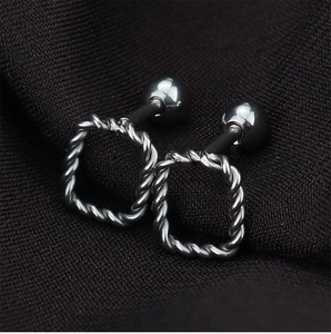 Macro view of silver geometric twist wire earrings with secure screw ball back closure