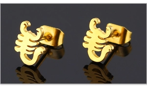 Detailed view of gold scorpion stud earrings on a reflective black background