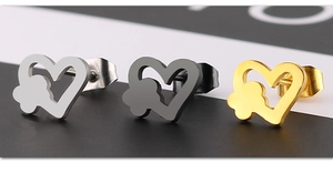 Macro shot of heart-shaped titanium steel studs in silver, black and gold finishes