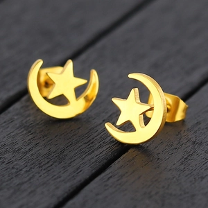 Elegant gold titanium steel moon and star stud earrings on a dark wooden surface