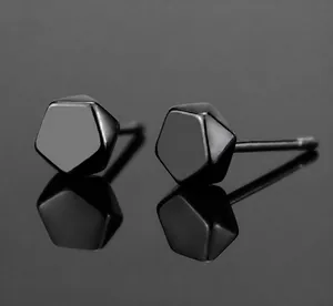 Detailed close-up of polished black pentagon geometric stud earrings with mirror reflection