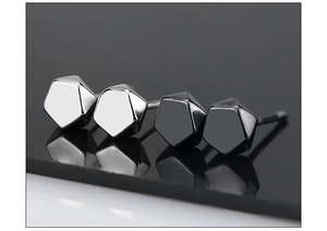 Macro shot of geometric pentagonal facet stud earrings in silver and black metal