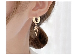 Close-up of a gold stainless steel hoop earring with a hollow triangle and star charm