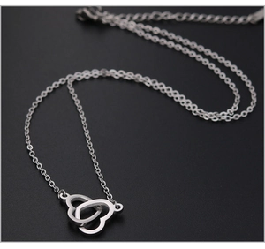 Macro-opname van de verstrengelde drievoudige hartvormige hanger aan een zilveren ketting