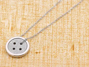 Gedetailleerde close-up van een zilveren druppelhanger met glittertextuur aan een ketting