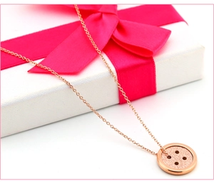 Macro-opname van de mat roze goudkleurige knop ketting op een geschenkverpakking