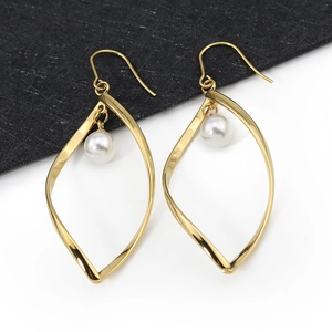 Elegante gouden blad oorbellen met witte parels en een minimalistisch vishaak ontwerp