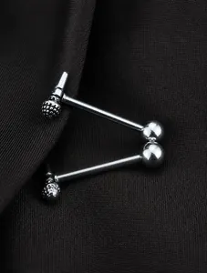Gros plan de piercings haltères en forme de microphone argenté avec boule polie sur tissu texturé