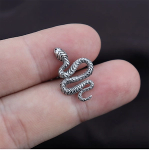 Macro d'un piercing de langue serpent en acier titane argenté montrant les écailles