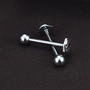 Vue macro des piercings de langue en acier inoxydable avec crâne et finition polie