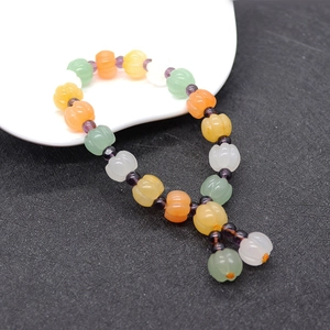 Macro view of colorful pumpkin-shaped natural stone beads with purple spacers