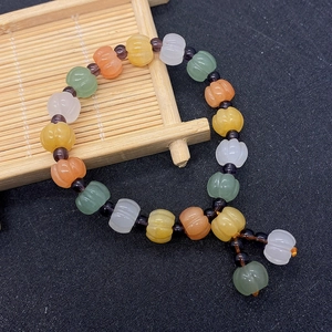 Macro detail of pumpkin shaped natural stone beads on a bamboo tray with purple spacers
