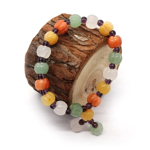 Multicolor pumpkin-shaped natural stone bead bracelet displayed on a wooden stand