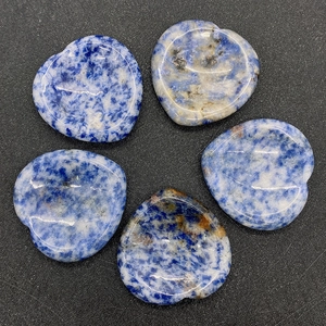 Détail macro de cinq pierres de sodalite en forme de cœur aux textures et motifs polis
