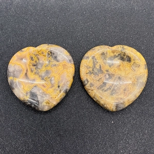 Macro detail of two heart-shaped natural agate thumb stones with unique lace textures