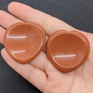 Macro shot of polished heart-shaped goldstone beads with shimmering metallic sparkles