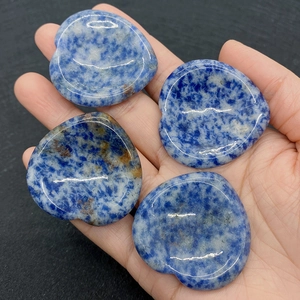 Détail macro de quatre pierres naturelles bleues en forme de cœur dans la main