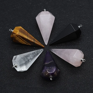 Macro detail of hexagonal natural stone pendants with polished facets and silver metal rings