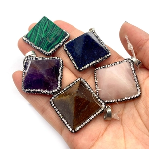Five pyramid natural stone pendants with malachite and lapis lazuli in a hand