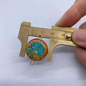 Messung eines 20mm runden Naturstein-Anhängers mit Goldfassung und zwei Ösen