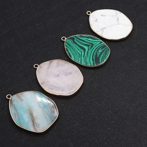 Macro detail of irregular natural stone pendants with gold plating and metallic rings