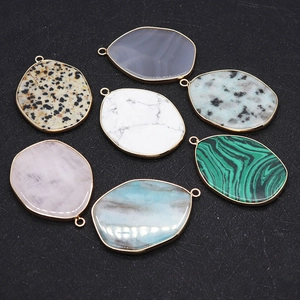 Macro view of natural stone pendants with gold metal edging and irregular shapes