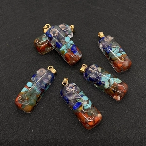 Detailed macro shot of rectangular resin pendants with colorful crushed stones and copper wire