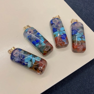 Detailed view of handmade rectangular chakra resin pendants with natural crushed stones