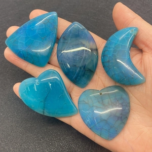 Macro detail of five blue dragon vein agate pendants in moon and heart shapes