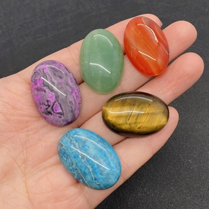 Detailed view of oval gemstone cabochons including tiger eye and green aventurine