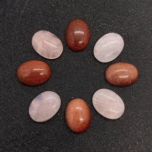 Gros plan de cabochons ovales en quartz rose et pierre de soleil pour bijoux DIY