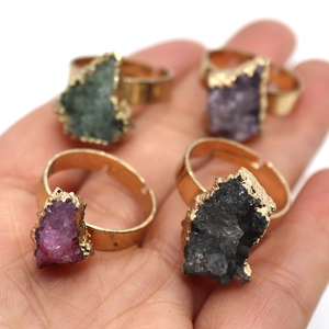 Detailed shot of four irregular raw crystal rings with gold edges and adjustable bands