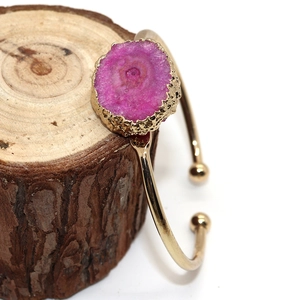 Bracelet manchette ajustable doré orné d'une grande agate géode rose de forme irrégulière