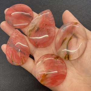 Macro view of five natural strawberry quartz pendants in various shapes with drill holes
