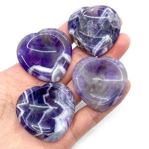 Vue rapprochée de pierres de guérison en améthyste violette polies en forme de cœur