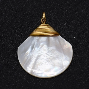 Pendentif en coquillage naturel avec fil doré torsadé sur fond noir texturé