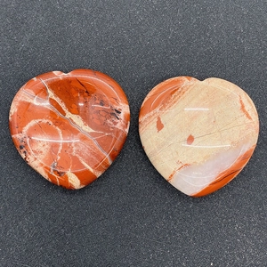 Vue macro de pierres de massage en forme de cœur en jaspe rouge naturel poli