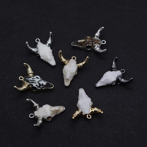 Detailed view of assorted resin bull head pendants with metallic horns in multiple finishes