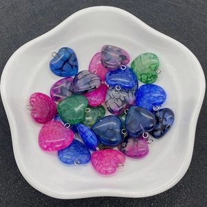 Gros plan de pendentifs cœurs en agate craquelée multicolore avec anneaux métalliques