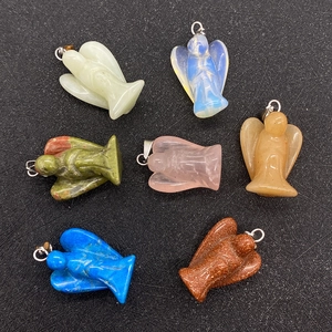 Dettaglio di sette ciondoli a forma di angelo in pietre preziose con ganci argentati