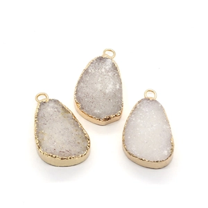 Detailopname van druzy kwarts hangers met goud vergulde randen voor DIY-sieraden maken