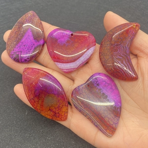 Macro detail of rice-shaped dragon vein agate pendants in purple and fuchsia tones