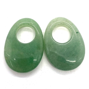 Detailed macro view of two green aventurine oval charms with large circular holes