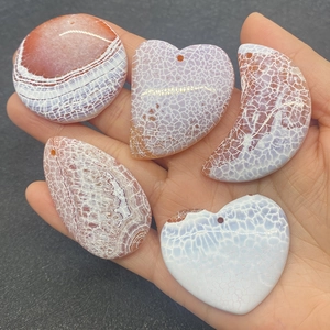 Detailed view of polished dragon vein agate pendants in moon, heart, and teardrop shapes
