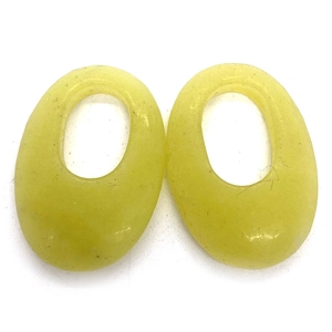 Close-up of translucent oval natural stone pendants with polished edges and core hole